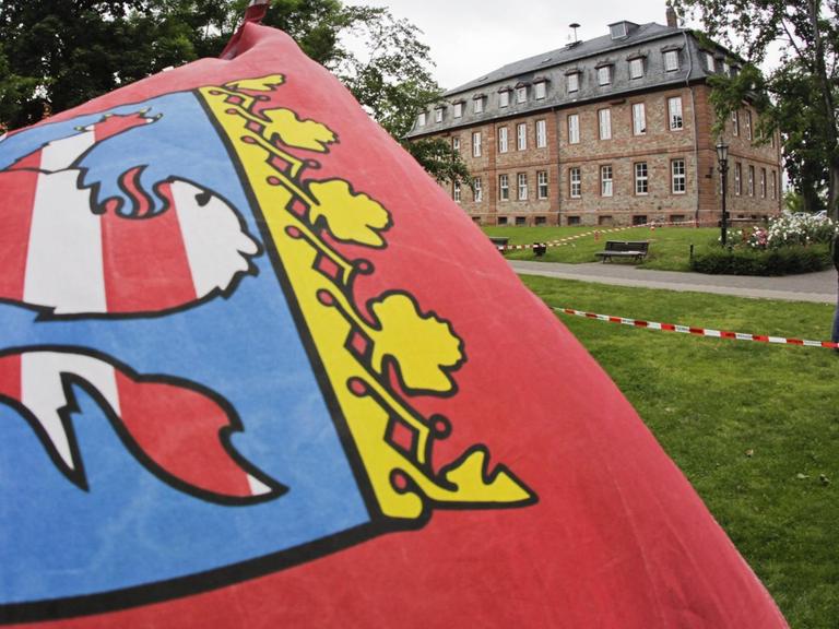 Eine hessische Landesfahne weht vor dem Schloss von Langenselbold, das heute als Rathaus dient.