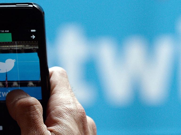 Ein Mann öffnet auf seinem Smartphone seinen Twitter-Account.