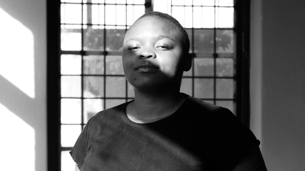 Ein Schwarz-Weiß-Porträt der südafrikanischen Künstlerin und Fotografin Khanyisile Mawhayi.