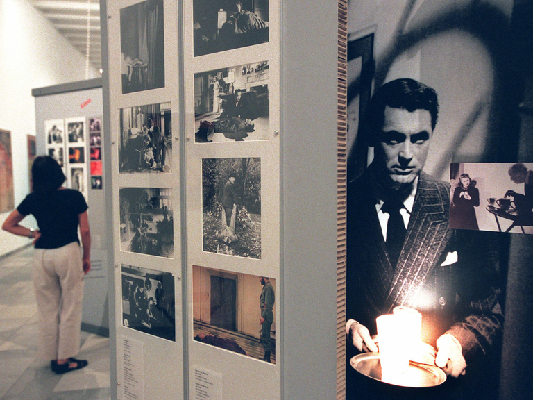  Filmposter mit einer Szene aus dem Streifen "Verdacht", in der von Schauspieler Cary Grant ein leuchtendes Glas Milch getragen wird.