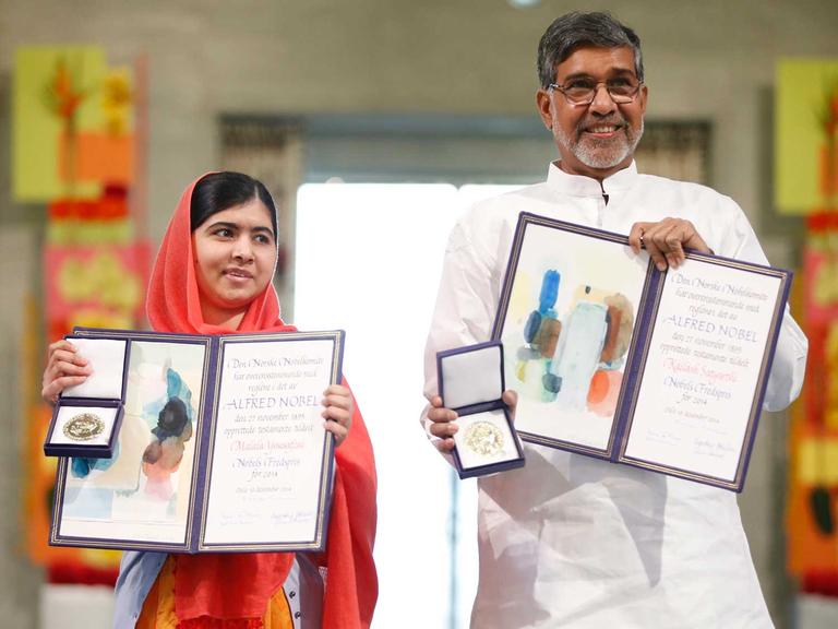 Malala Yousafzai (links) und Kailash Satyarthi zeigen ihre Nobelpreisurkunden und -Medaillen während der Preiszeremonie.