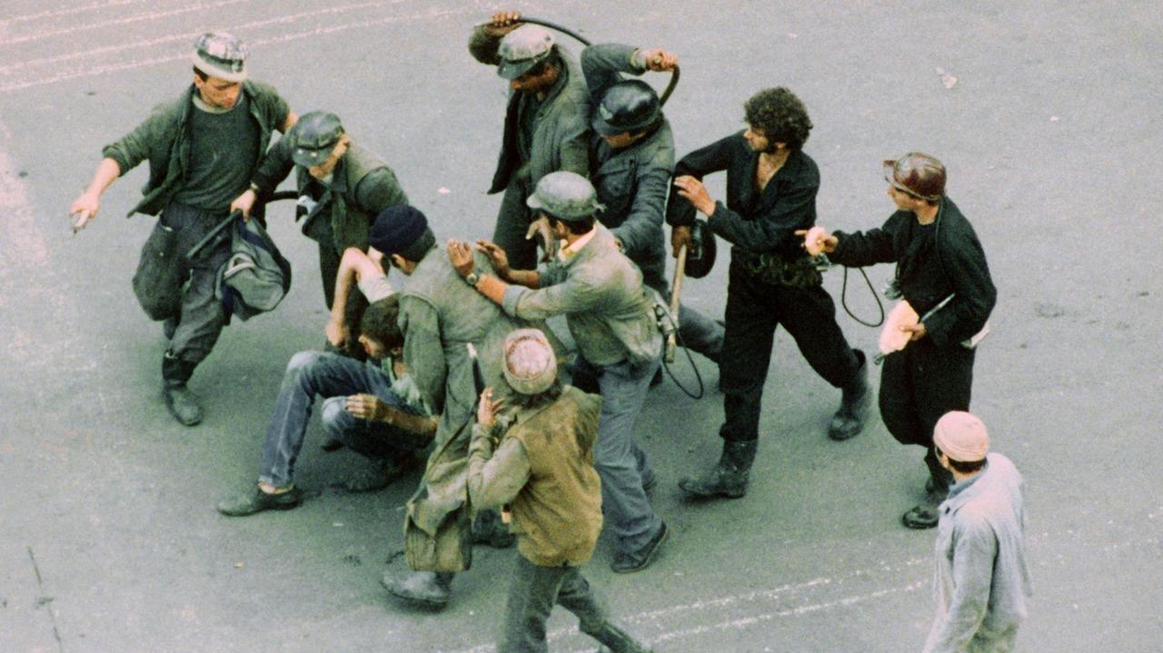 Bergarbeiter verprügeln am 18. Juni 1990 auf offener Straße einen Demonstranten. Rund 8.000 Bergleute aus den rumänischen Kohlerevieren kamen nach den gewalttätigen Unruhen in Bukarest Präsident Iliescu zu Hilfe.