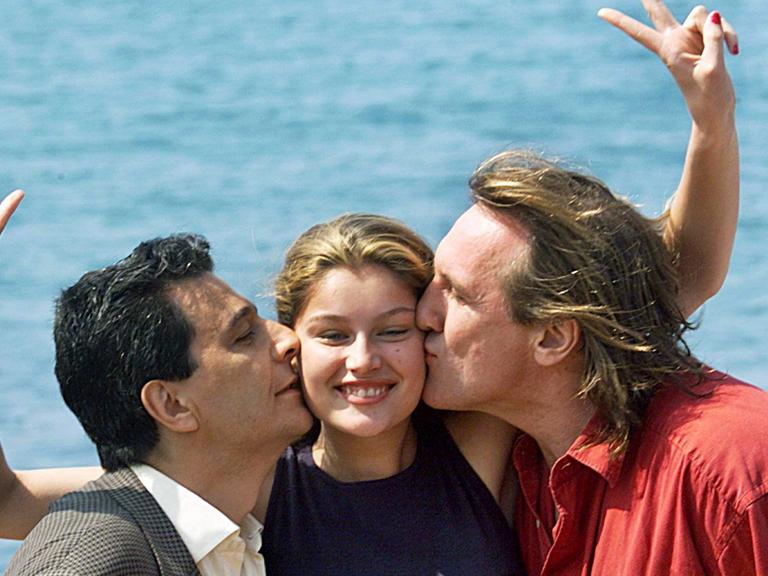 Die Schauspieler Christian Clavier und Gerard Depardieu küssen Model und Schauspielerin Laetitia Casta in Cannes, Archivfoto von 1998