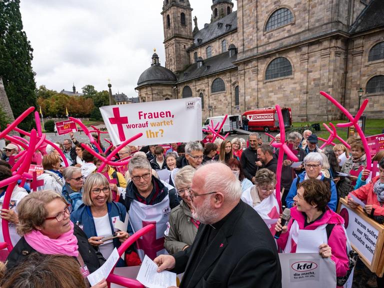 Hessen, Fulda: Kardinal Reinhard Marx (M), Vorsitzender der Deutschen Bischofskonferenz, trifft vor dem Fuldaer Dom zu Beginn der Herbstvollversammlung der Deutschen Bischöfe mit Demonstrantinnen der Katholischen Frauengemeinschaft Deutschlands zusammen, die mehr Geschlechtergerechtigkeit in der Kirche fordern.