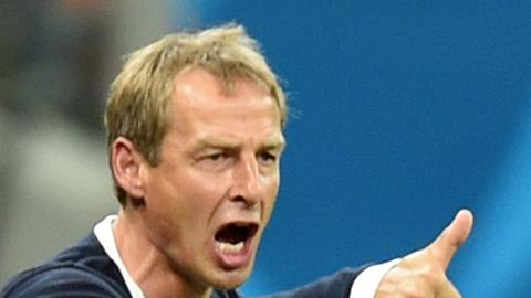 Jürgen Klinsmann reckt den rechten Daumen hoch und schreit über den Platz