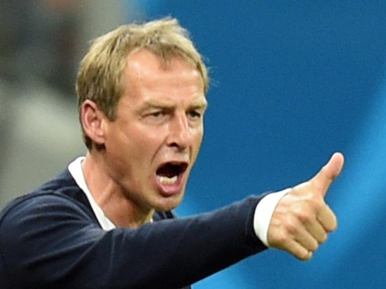 Jürgen Klinsmann reckt den rechten Daumen hoch und schreit über den Platz