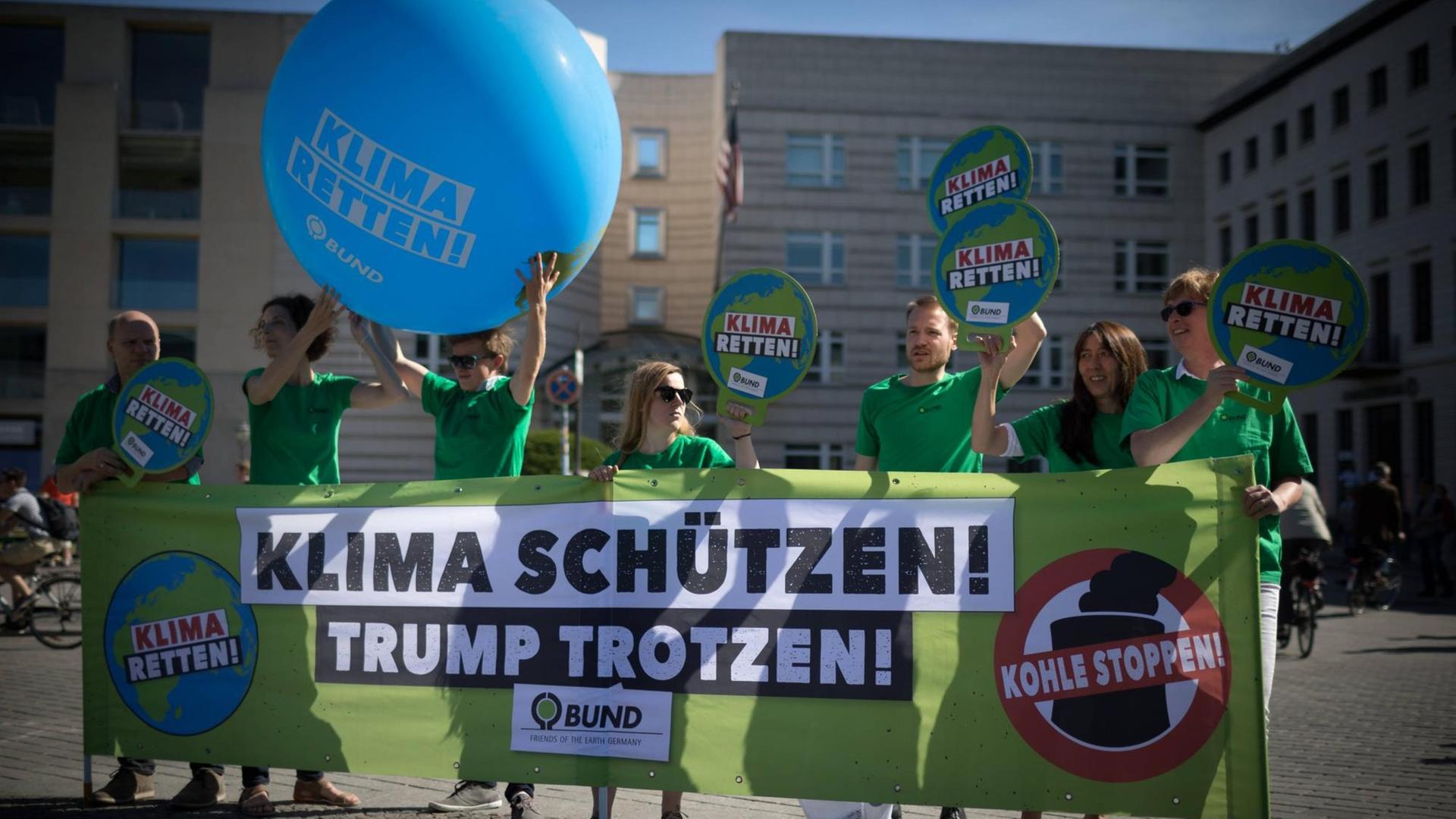 Aktivisten der Umweltorganisation demonstrieren gegen die Klimapoltik der USA mit Transparenten