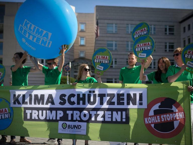 Aktivisten der Umweltorganisation demonstrieren gegen die Klimapoltik der USA mit Transparenten