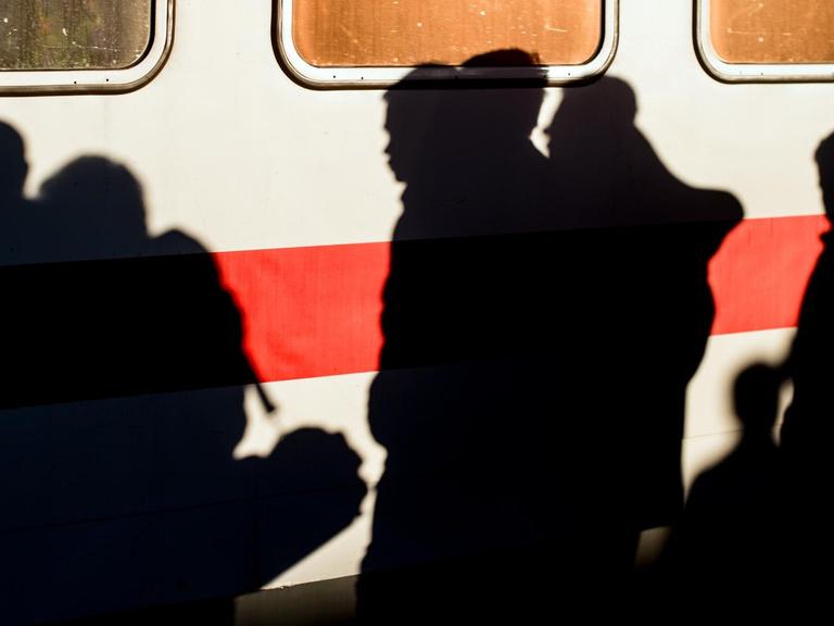 An einem stehenden Zug-Waggon zeichnen sich Schatten von Flüchtlingen ab. 
