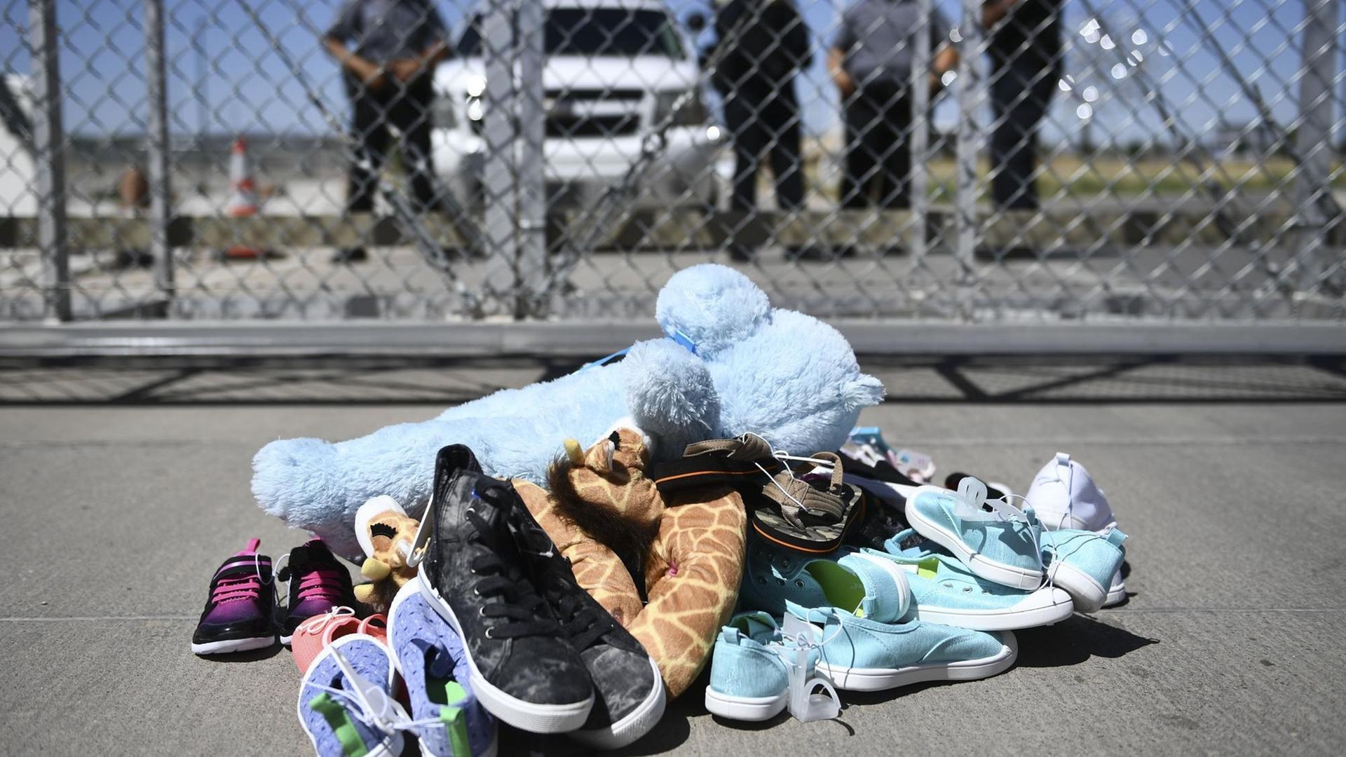 Schuhe und Teddybären vor dem Zaun des Tornillo-Flüchtlingslagers in der Nähe von El Paso, Texas, während einer Protestkundgebung US-amerikanischer Kommunalpolitiker gegen die Politik der Familientrennung der Trump- Administration