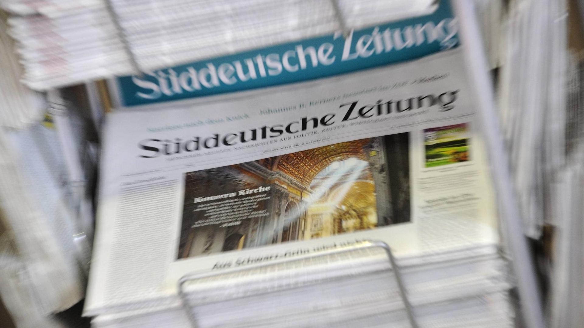 Eine Ausgabe der Süddeutschen Zeitung liegt in einem Zeitungsständer aus