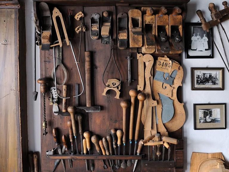 Blick auf viel verschiedenes Spezialwerkzeug, das an einer Wand in einer Geigenbau-Werkstatt hängt. 