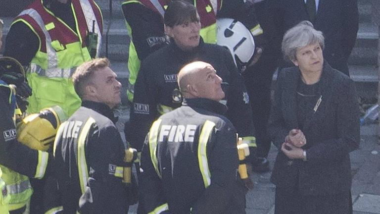 Premierministerin May im Gespräch mit Feuerwehrleuten am ausgebrannten Grenfell Tower in London