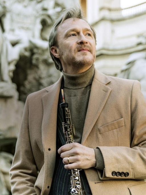 Porträt von Albrecht Mayer mit seiner Oboe in der Hand.