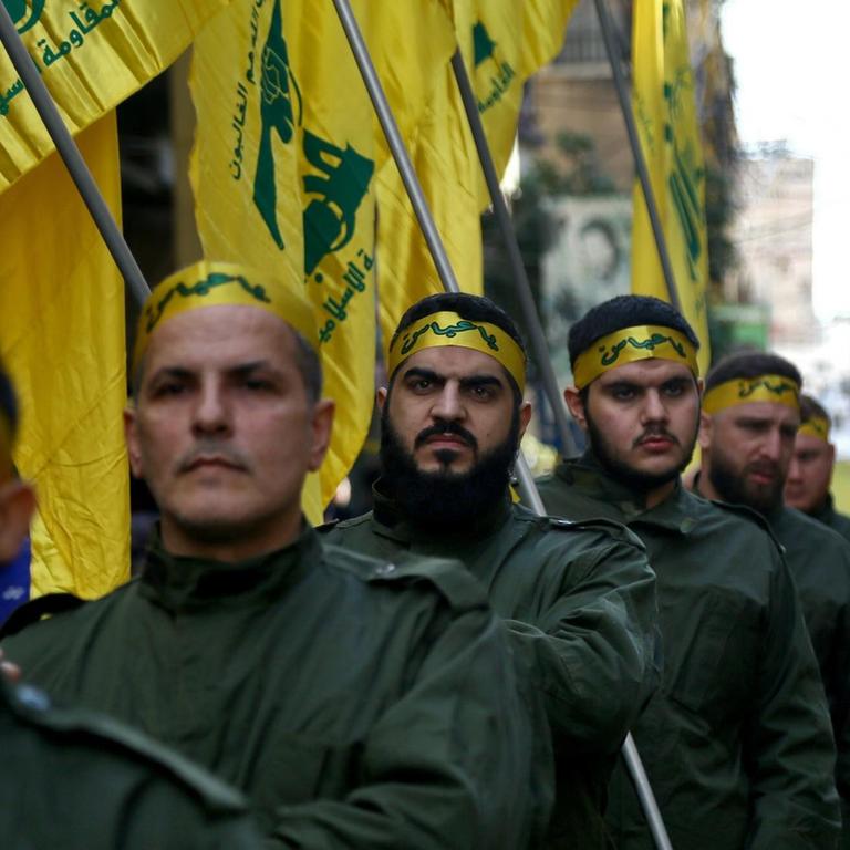 Pro-iranische Hisbollah-Kämpfer halten während des Trauerzuges von fünf ihrer Kollegen, die bei Zusammenstößen mit der türkischen Armee in der syrischen Provinz Idlib getötet wurden, Fahnen in der Hand. 