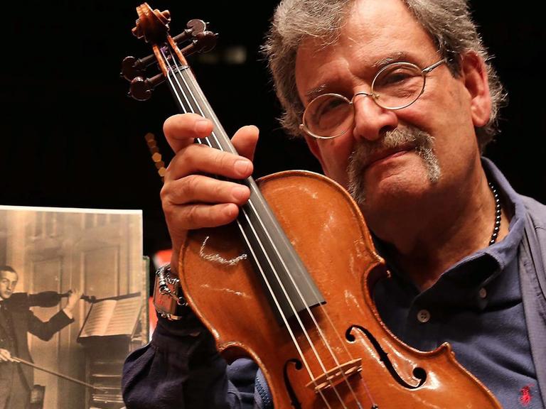 Geigenbauer Amnon Weinstein mit einer von ihm restaurierten Violine bei der Ausstellung "Violins of Hope" in Monaco.