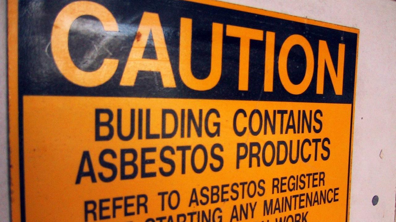 "Caution. Building contains asbestos products" steht auf einem Warnschild in Australien.