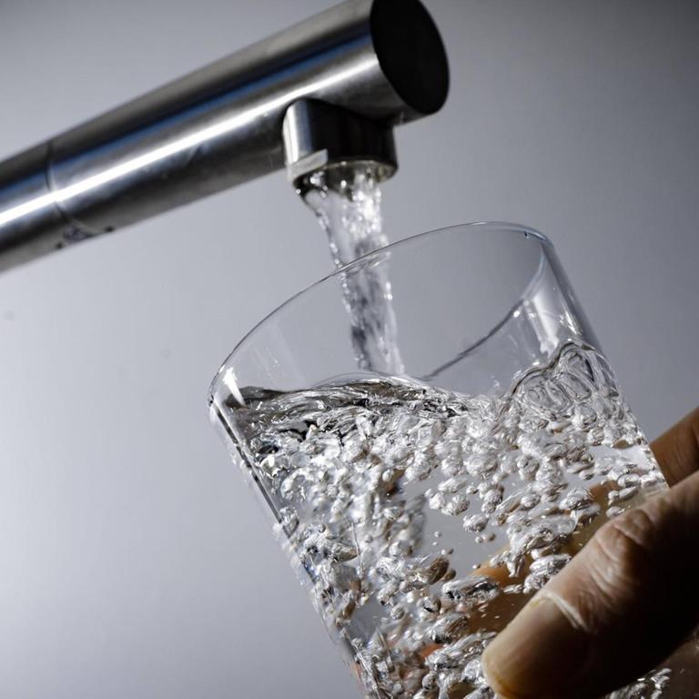 Symbolfoto: Wasser fließt aus einem Wasserhahn in ein Glas.