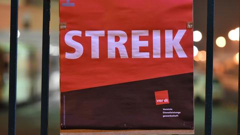Ein Verdi-Plakat mit dem Text "Streik" hängt an einem Metallzaun.