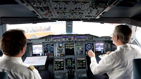 Zwei Piloten arbeiten am 05.06.2014 auf dem Flughafen in Hamburg im Cockpit eines Lufthansa-Airbus A380.