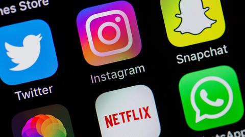 Auf einem Smartphone-Display sind die Logos von Twitter, Instagram und Snapchat zu sehen.