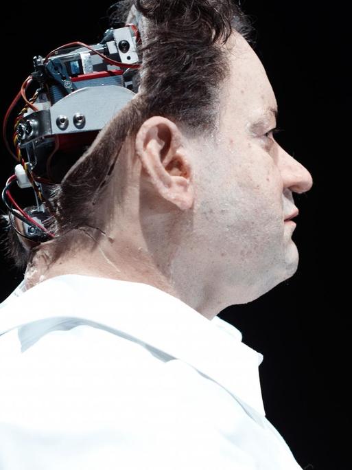 Kopf eines Mannes, der von hinten offenbart, dass der Kopf eine Maschine ist.
