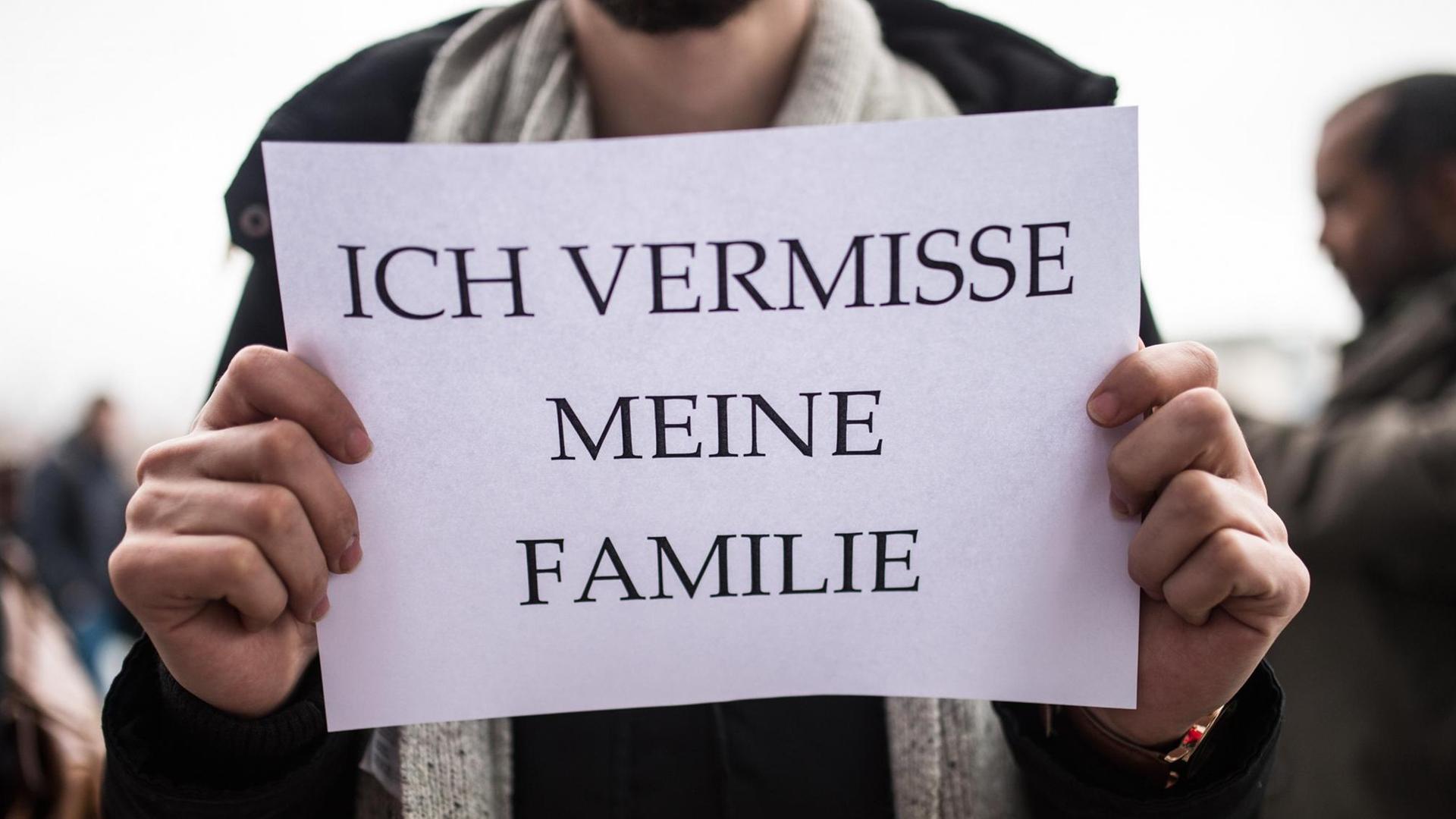 Ein Mitglied des Flüchtlingsrats Berlin hält ein Schild mit der Aufschrift «Ich vermisse meine Familie» in den Händen.