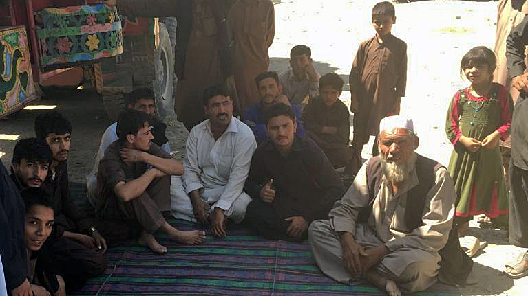 Fahid Rahim und ihre Familien hocken vor dem Lkw, mit dem sie gekommen sind. Sie haben 1500 Dollar für die eigene Abschiebung gezahlt, sehr viel Geld für die Familie.