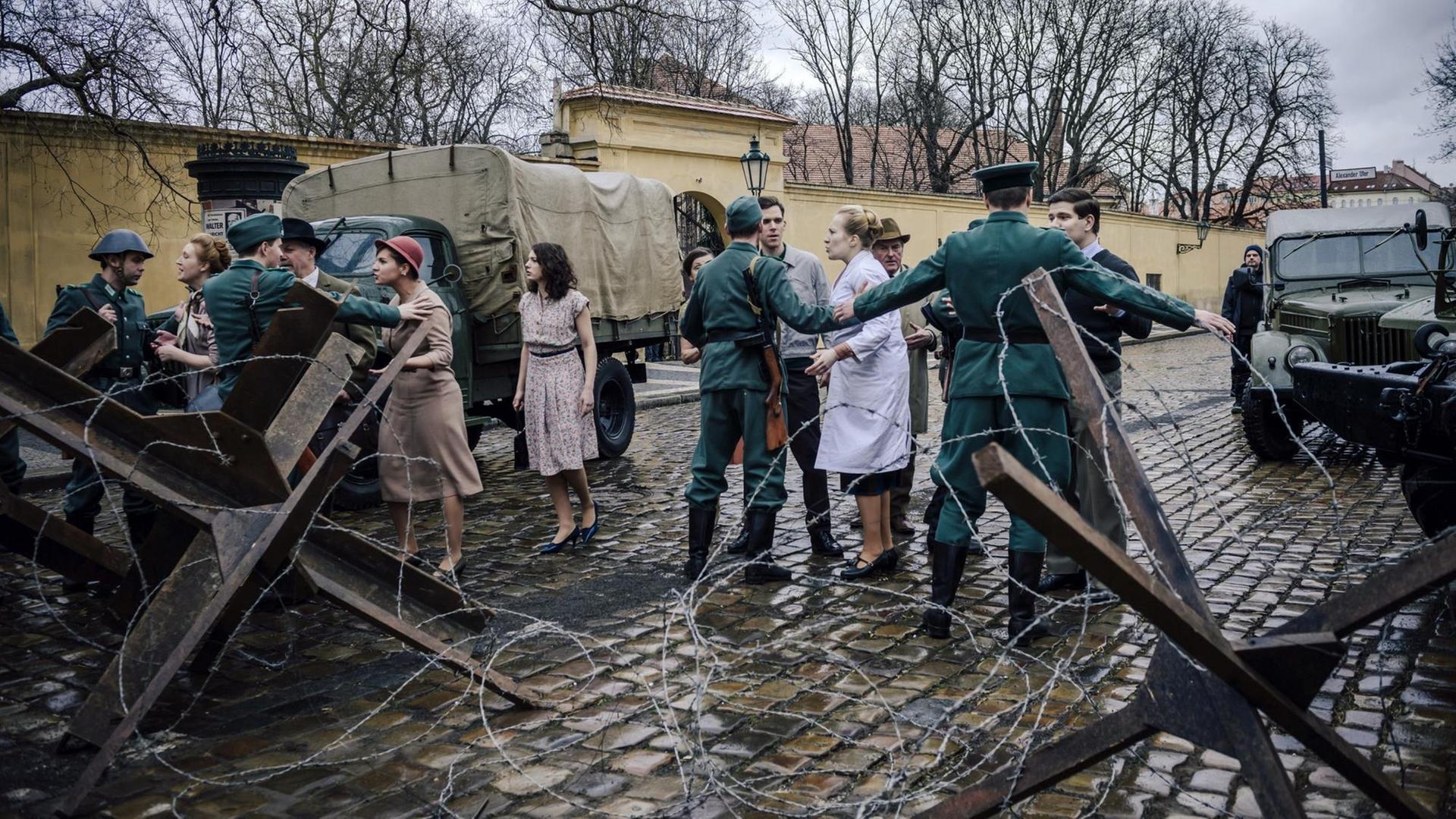 Vor der Charité wird eine Mauer errichtet - Soldaten halten Passanten zurück.