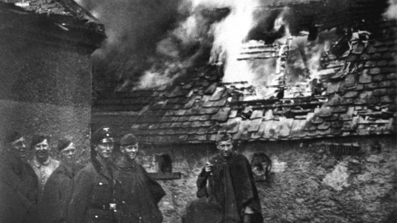 Deutsche Soldaten am 10. Juni 1942 in Lidice vor brennenden Gebäuden. Als Vergeltungsaktion für das von tschechoslowakischen Widerstandskämpfern am 27.5.1942 verübte Attentat auf den Nazi-Statthalter in Prag, Heydrich, den stellvertretenden Reichsprotektor von Böhmen und Mähren, überfiel die SS am 9. Juni 1942 die fast 500 Einwohner zählende Gemeinde Lidice. In der Nacht zum 10. Juni wurden alle Männer erschossen, Frauen und Kinder in das Konzentrationslager Ravensbrück verschleppt. Das Dorf wurde dem Erdboden gleichgemacht.