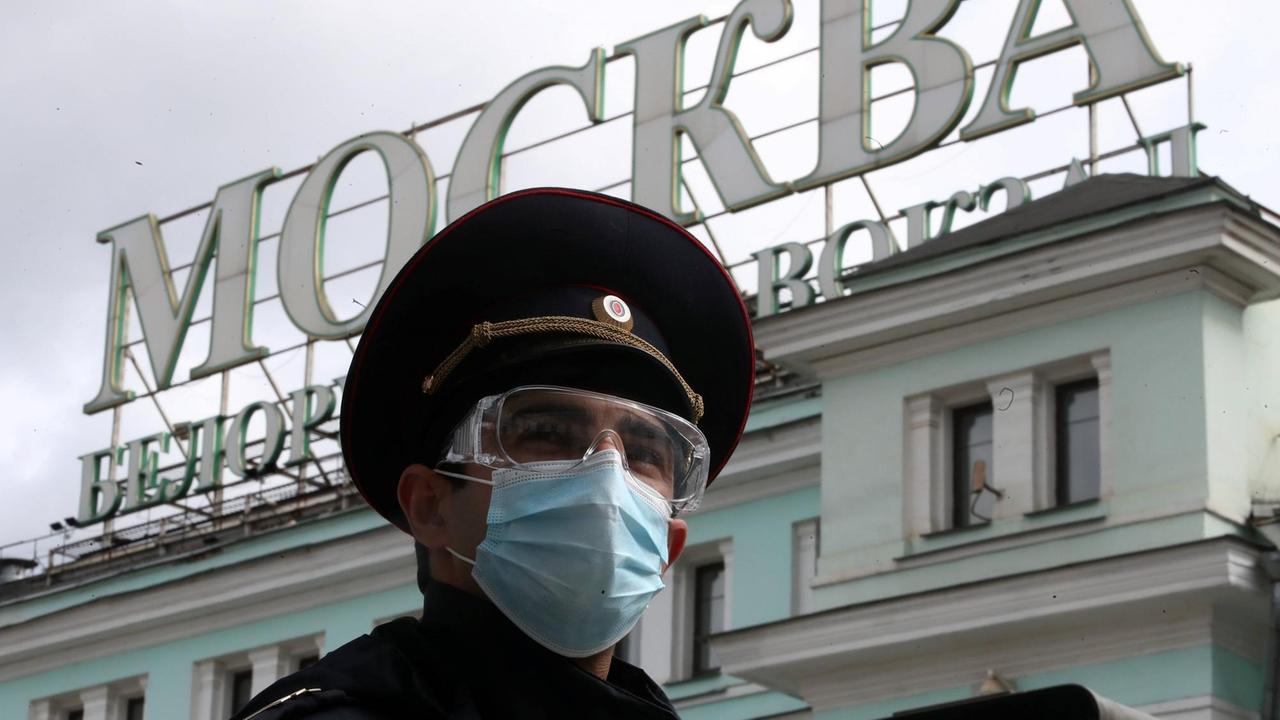 Ein Polizist mit Atemschutzmaske vor dem Bahnhof Belorussky in Moskau.