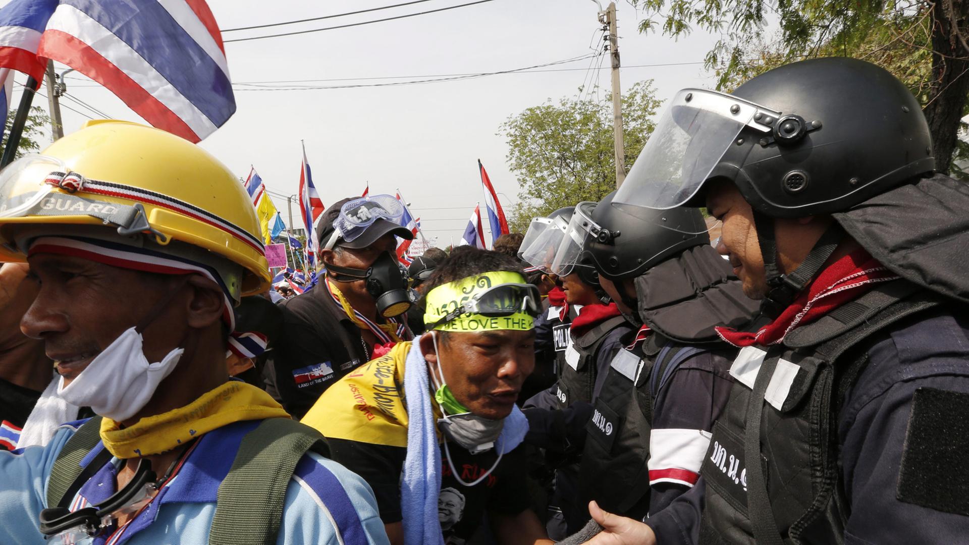 Protestler und Polizisten schütteln sich in Bangkok am 03.12.2013 die Hände