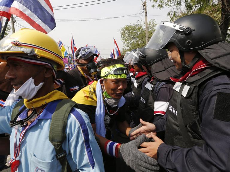Protestler und Polizisten schütteln sich in Bangkok am 03.12.2013 die Hände