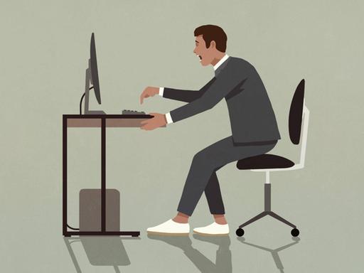 Ein Mann im Anzug sitzt mit aufgeregtem Gesichtsausdruck an seinem Schreibtisch und tippt mit übertriebener Geste auf die Tastatur vor sich.