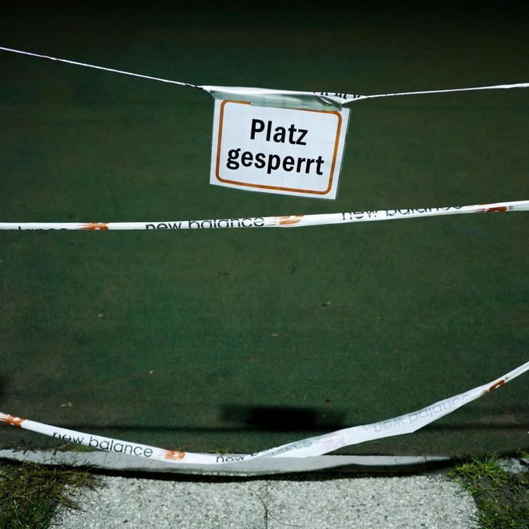 Ein Schild mit der Aufschrift "Platz gesperrt" hängt vor dem Eingang zu einem Tennisplatz.