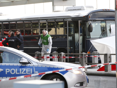 Polizisten stehen auf dem Flughafengelände Frankfurt am Main nach dem Angriff auf einen US-Militärbus neben dem Fahrzeug. 