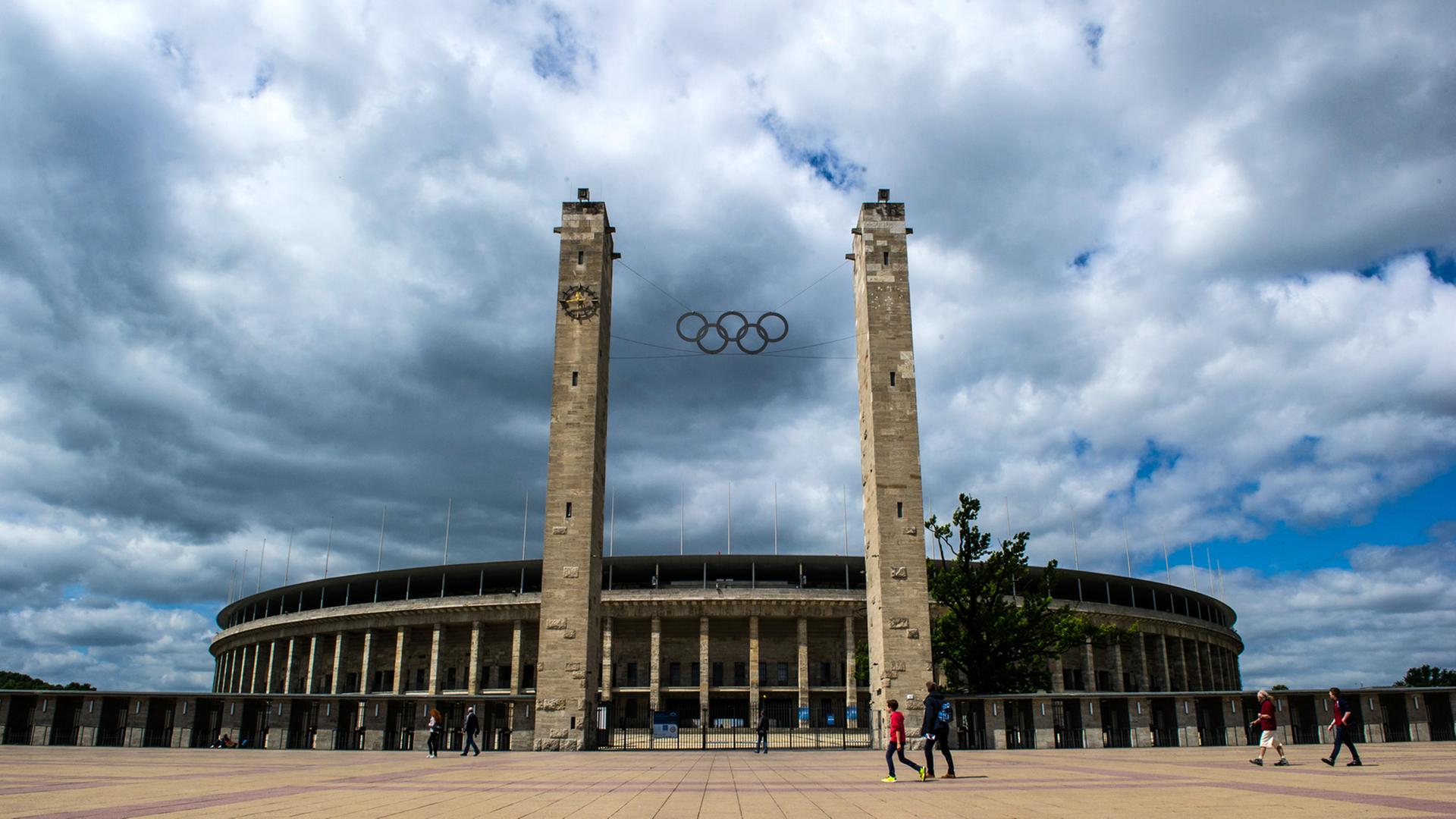 Menschen gehen am 23.06.2014 in Berlin am Olympiastadion vorbei.
