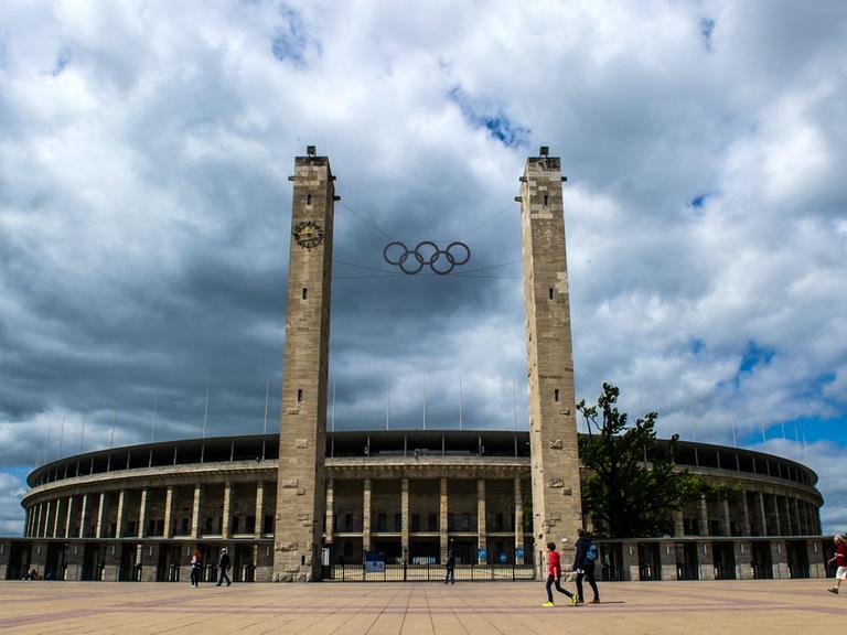 Menschen gehen am 23.06.2014 in Berlin am Olympiastadion vorbei.