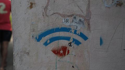 Das W-Lan-Zeichen auf einer Hauswand in den Farben der kubanischen Flagge.