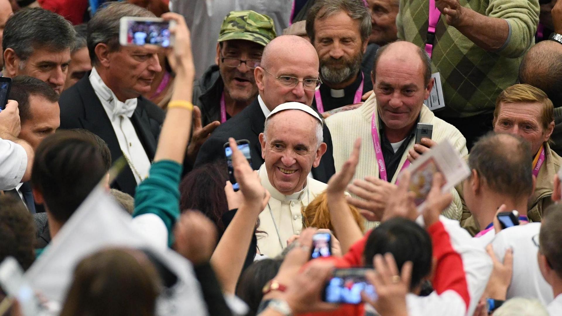 Papst Franziskus in einer Gruppe von Obdachlosen, die er zu einer Audienz im Vatikan empfangen hat.
