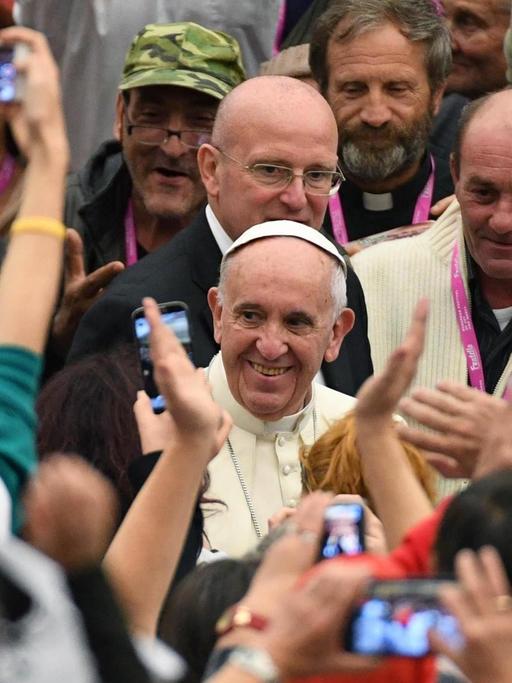 Papst Franziskus in einer Gruppe von Obdachlosen, die er zu einer Audienz im Vatikan empfangen hat.