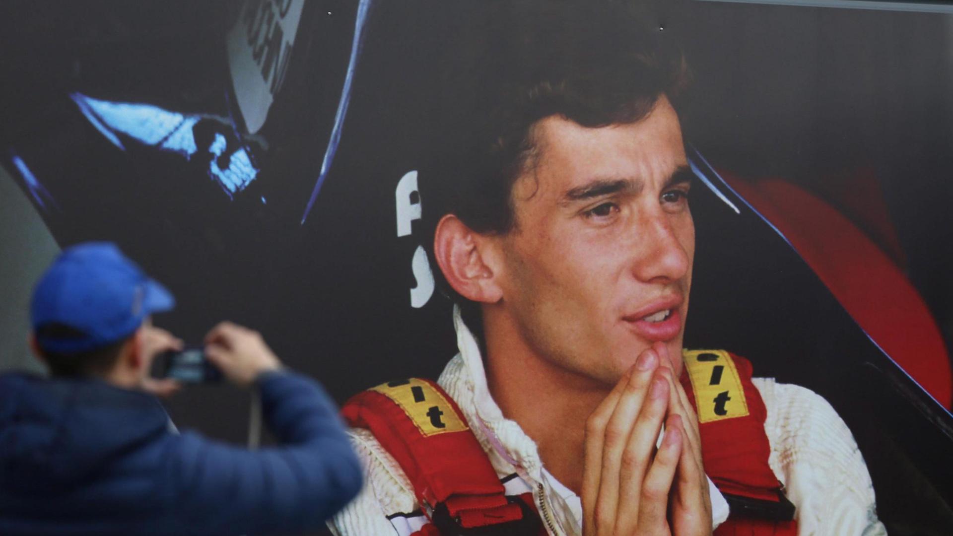 Ein Mann fotografiert ein Poster des am 1. Mai 1994 tödlich verunglückten Ayrton Senna. Ein Mann fotografiert ein Poster des am 1. Mai 1994 tödlich verunglückten Ayrton Senna.