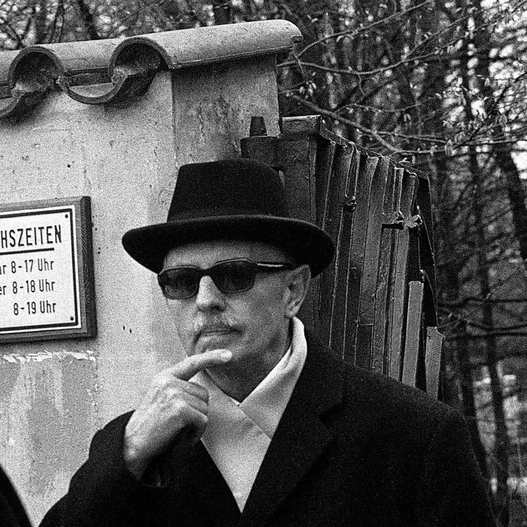 Schwarz-weiß Foto von Reinhard Gehlen, Leiter des BND von 1956 bis 1968, mit Sonnenbrille und Hut am 7. April 1972 am Ausgang eines Müncher Friedhofes.
