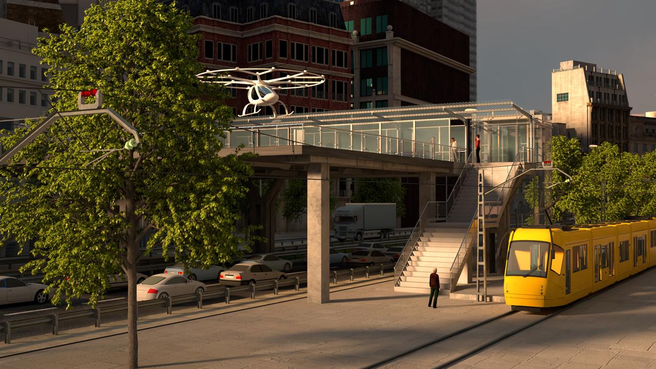 Eine Illustration zeigt wie es funktionieren soll: Ein Volocopter landet auf einem Hub über einer Straße mitten in der Stadt.