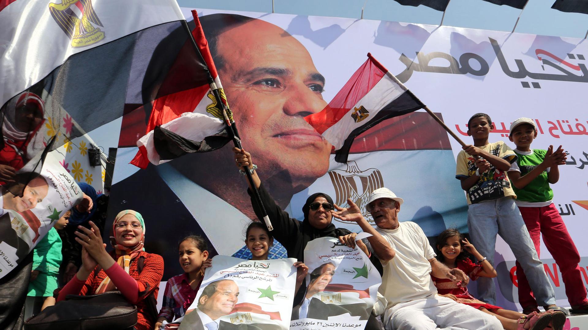 Supporters of Egypt's former Defense Minister Abdel Fattah al-Sissi hold campaign posters with his portrait during a rally in Cairo, Egypt, 23 May 2014. Egypt's presidential election will take place on 26 and 27 May 2014.