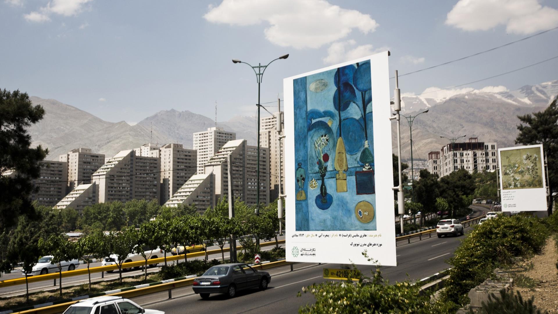 Blick auf eine große Straße in Teheran, am Rand der Straße sind Bilder von Künstlern wie Picasso oder Matisse auf Werbeplakaten zu sehen.