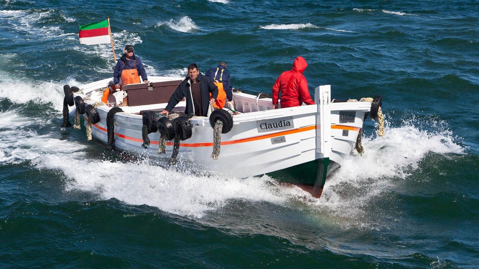 Ein Börteboot fährt vor Helgoland übers Meer.