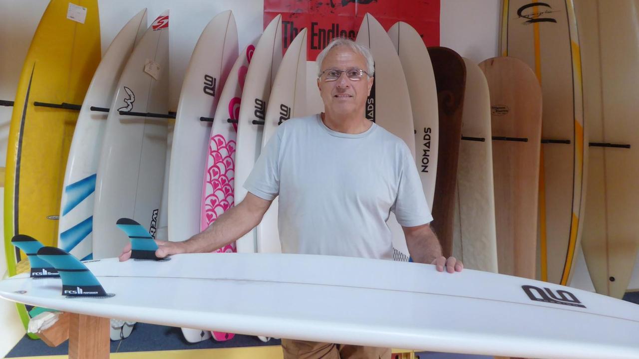 Gerard Depeyris verkauft Surfbretter in Lacanau. Er plädiert dafür, die Häuser und Geschäfte von der Uferzeile rasch ins Landesinnere zu verlegen. Weil er verhindern will, dass zukünftige Generationen die Fehler der Vergangenheit ausbaden müssen.