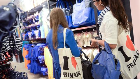 Zwei junge Frauen sehen sich am 03.07.2014 in Berlin bei der Eröffnung einer Primark-Filiale Kleidung an.