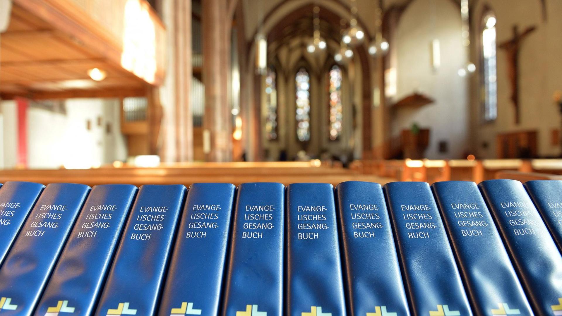 Das Bild zeigt eine Reihe von Evangelischen Gesangbüchern in der Leonardskirche in Stuttgart.